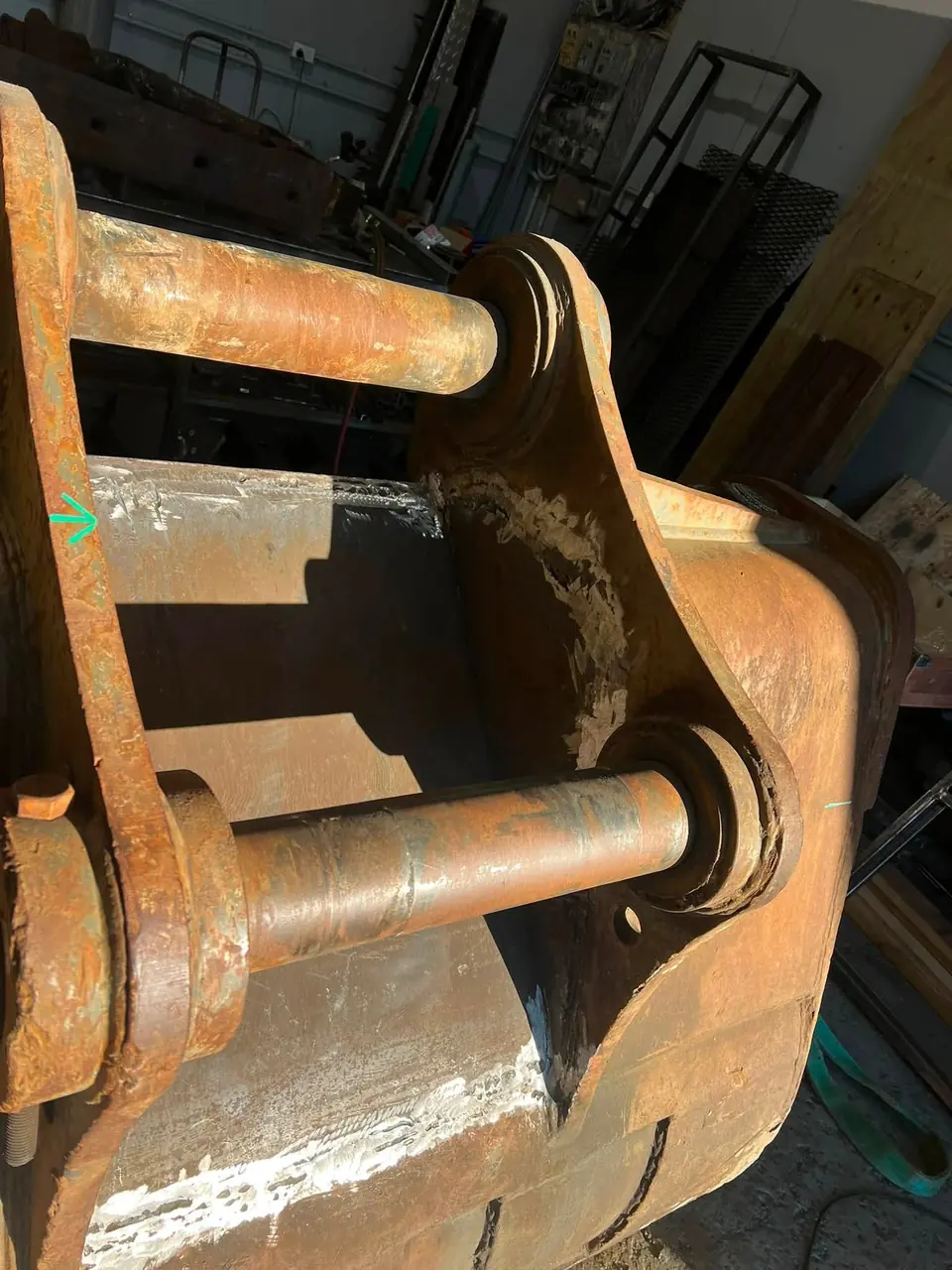 Close up of an excavator bucket hitch and pins in the workshop