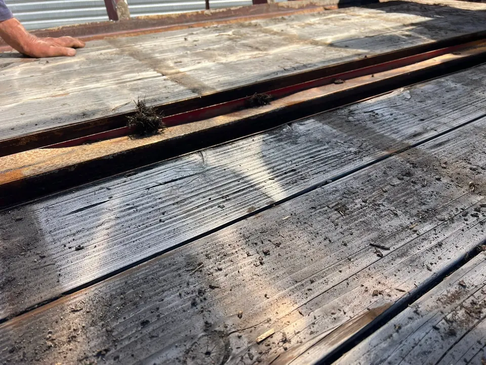 Worn original decking timbers in the silage wagon before replacement